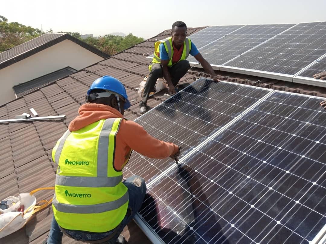 two men installing a solar panel on a roof