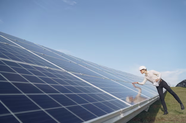 A man in a hard hat checks the quality of solar panels