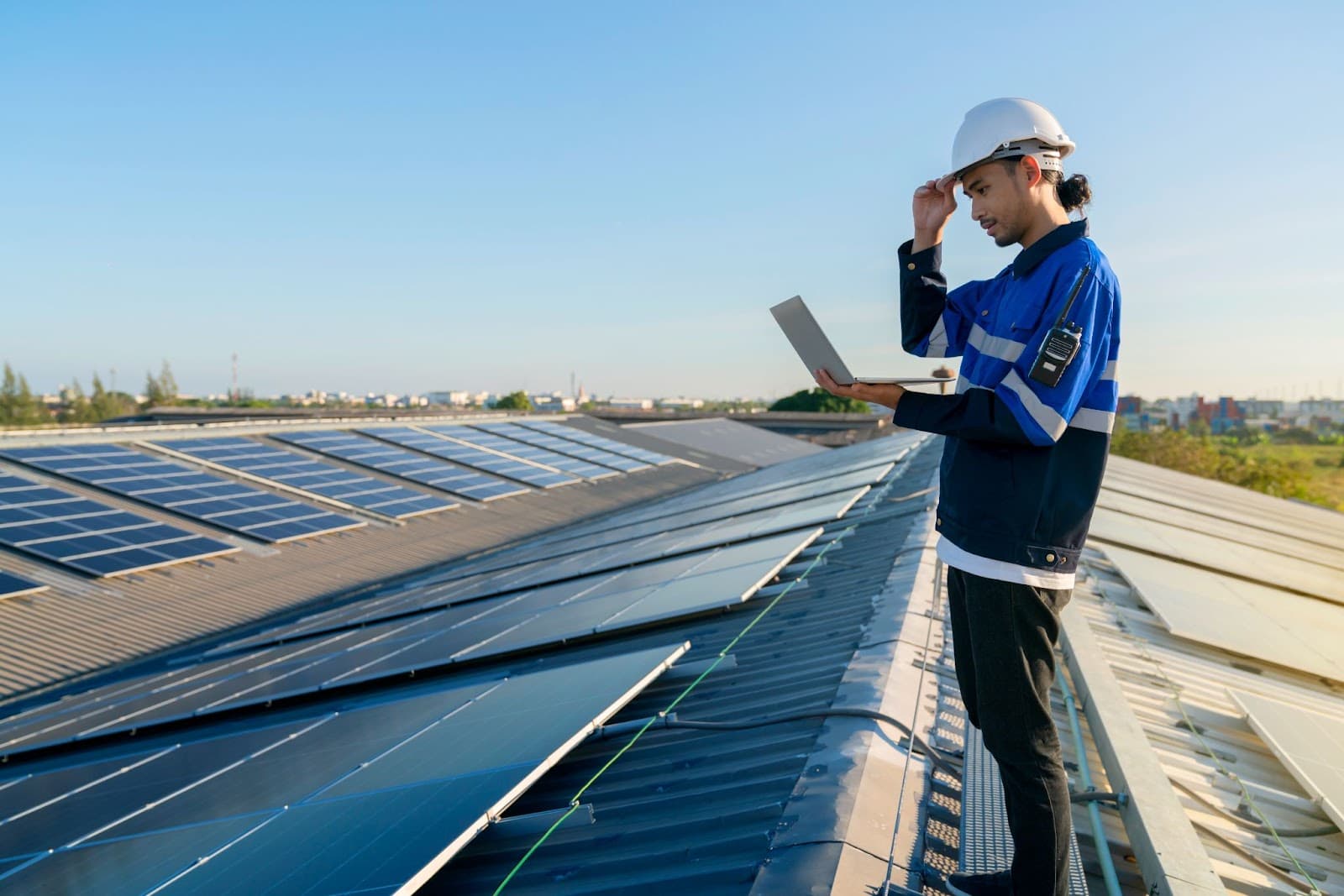 Engineer with laptop checking of installing solar roof panel