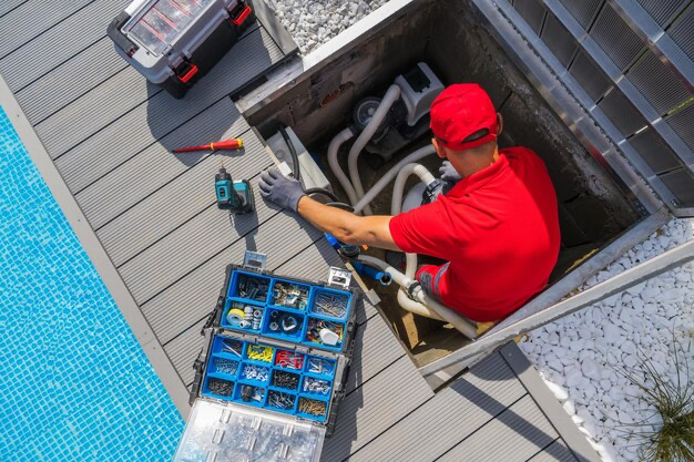 A man repairs a heater next to the pool