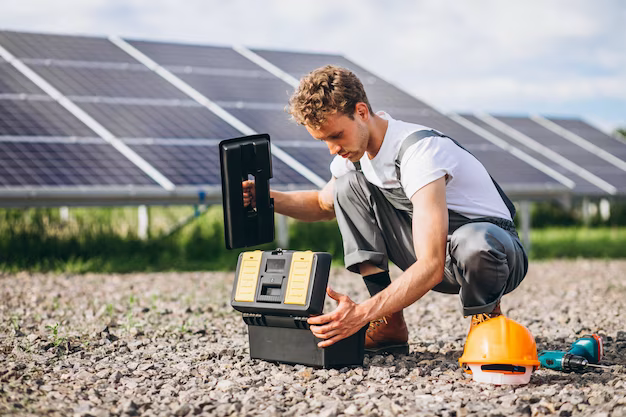 Man with a set of tools on a background of solar panels