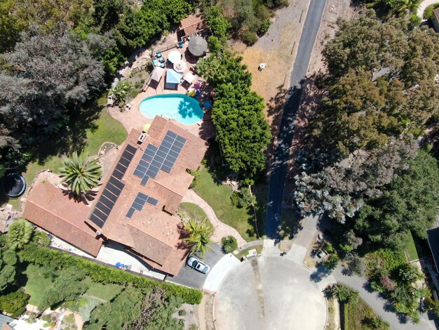 Aerial view of a large scale villa with solar panels on the roof